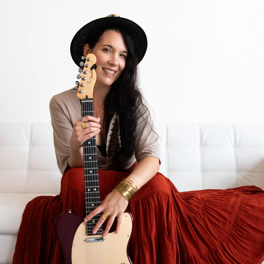 Portrait of Micaela Kingslight holding her guitar
