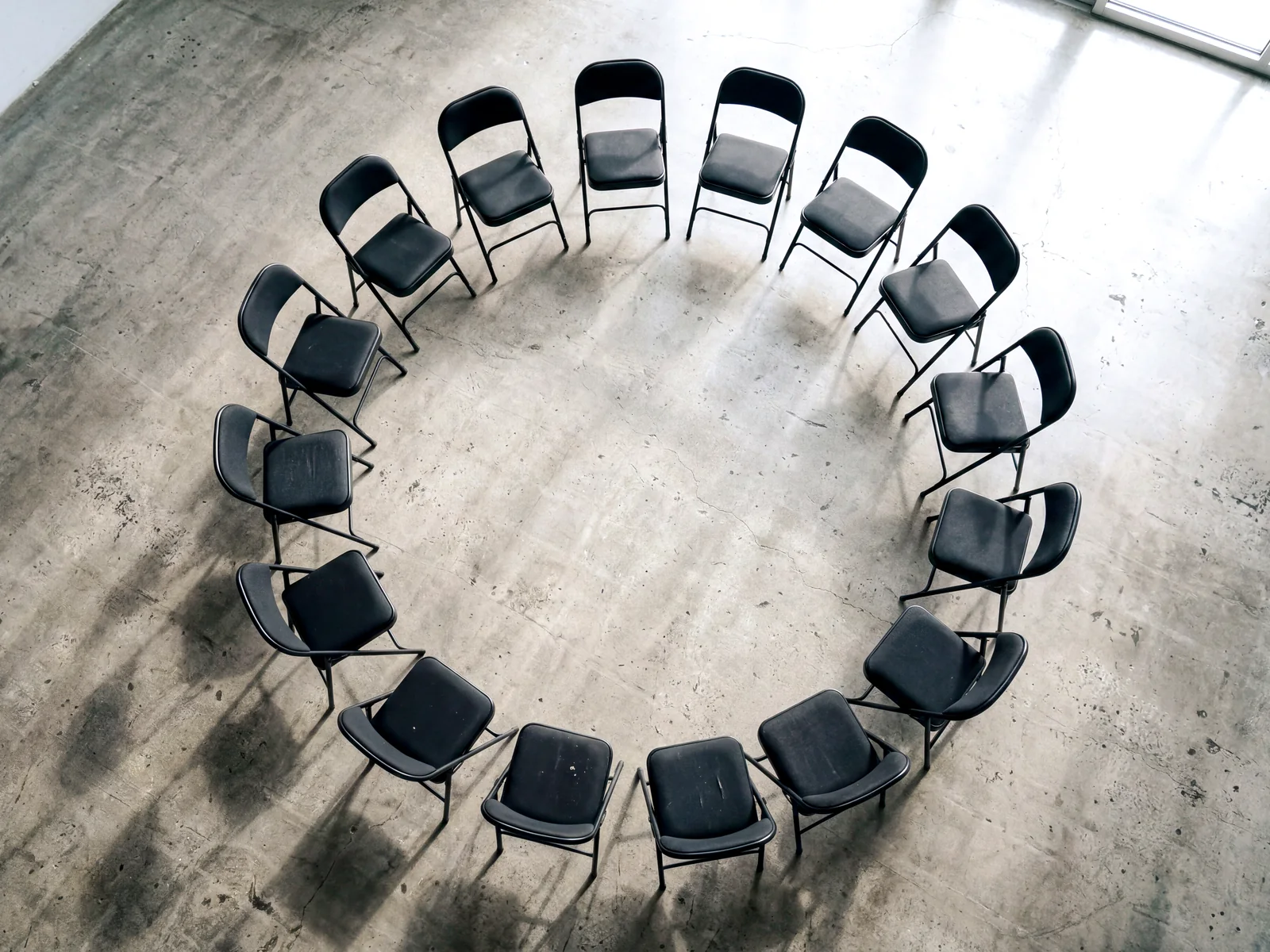 A circle of chairs arranged for shared experiential work